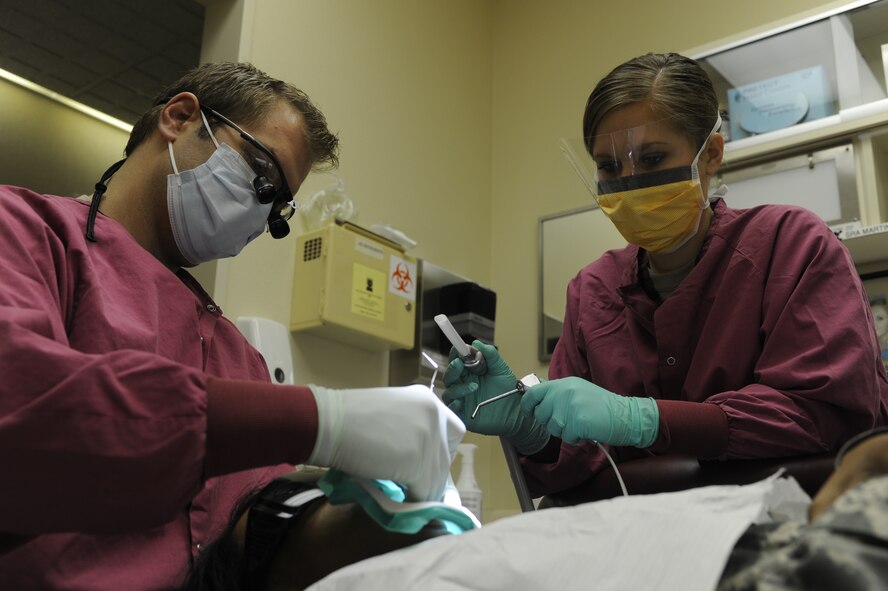 MINOT AIR FORCE BASE, N.D. -- Capt. Glenn Ashworth, 5th Medical Operations Squadron dentist, and Senior Airman Ashley Martin, 5th Medical Operations Squadron dental assistant, perform a root canal on a patient here Nov. 3. Teamwork is essential in allowing dentists to concentrate completely on the task at hand. (U.S. Air Force Photo/Airman 1st Class Stephanie Ashley)