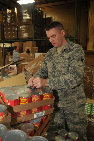 Staff Sgt. Chad Carter readies canned goods for assembly into food care packages Nov. 6 at Second Harvest Food Bank of Clark, Champaign and Logan Counties in Springfield, Ohio. Sergeant Carter volunteered with Springfield Air National Guard Base’s Airman/NCO Council to assemble 440 care packeages for underserved citizens in the tri-county area.