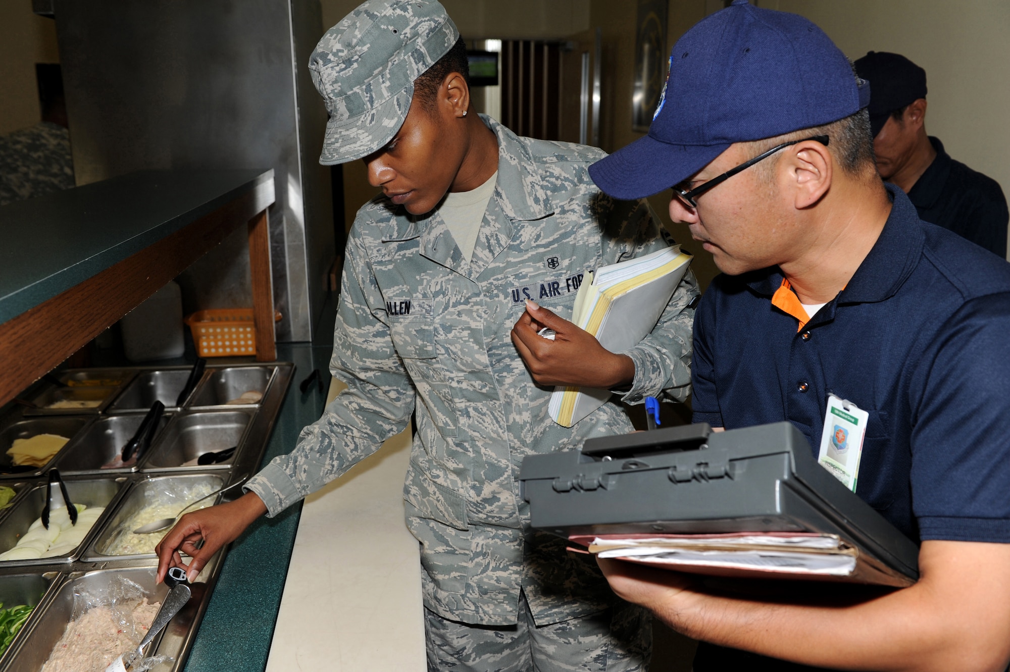 U.S. Air Force Airman 1st Class Brandy Allen, 18th Aerospace Medicine Squadron Public Health technician, checks the safe cold food holding temperatures at the Marshall Dining Facility during an inspection on Kadena Air Base, Japan, Nov. 8.  The public health inspection members help and educate during their food inspection visit and look for many things to include food preparation, proper temperature, food handling, prevention disease, quality and sanitations. (U.S. Air Force photo/Junko Kinjo/released)