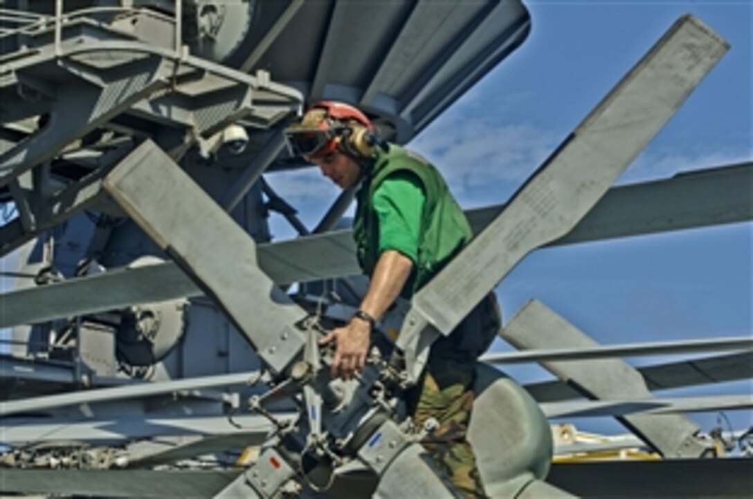 U.S. Navy Seaman John Kennedy conducts a flight inspection on the tail rotor of an SH-60 Sea Hawk helicopter aboard the aircraft carrier USS George Washington while on patrol in the Pacific Ocean, Nov. 6, 2011. 