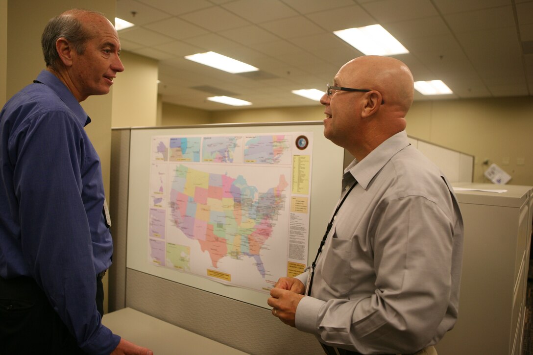 Doug Connor and Alain Flexer, the two energy managers for the Marine Forces Reserve Facilities Department, discuss future projects while studying a map showing the physical location of all 183 Home Training Centers throughout the U.S. and Puerto Rico. (Photo By: Sgt. Tyler J. Hlavac)