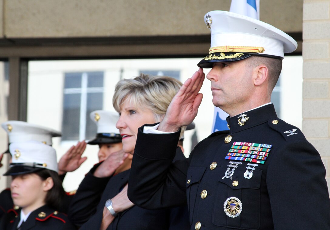 Col. Ted Studdard, commanding officer of the 8th Marine Corps District, salutes while Fort Worth mayor Betsy Price places her hand over her heart during the playing of the National Anthem during the Marine Corps birthday celebration at Fort Worth City Hall, Nov. 10.  The celebration featured a traditional cake cutting ceremony and a proclamation by the mayor declaring Nov. 10 as "Marine Corps Day" in the city.