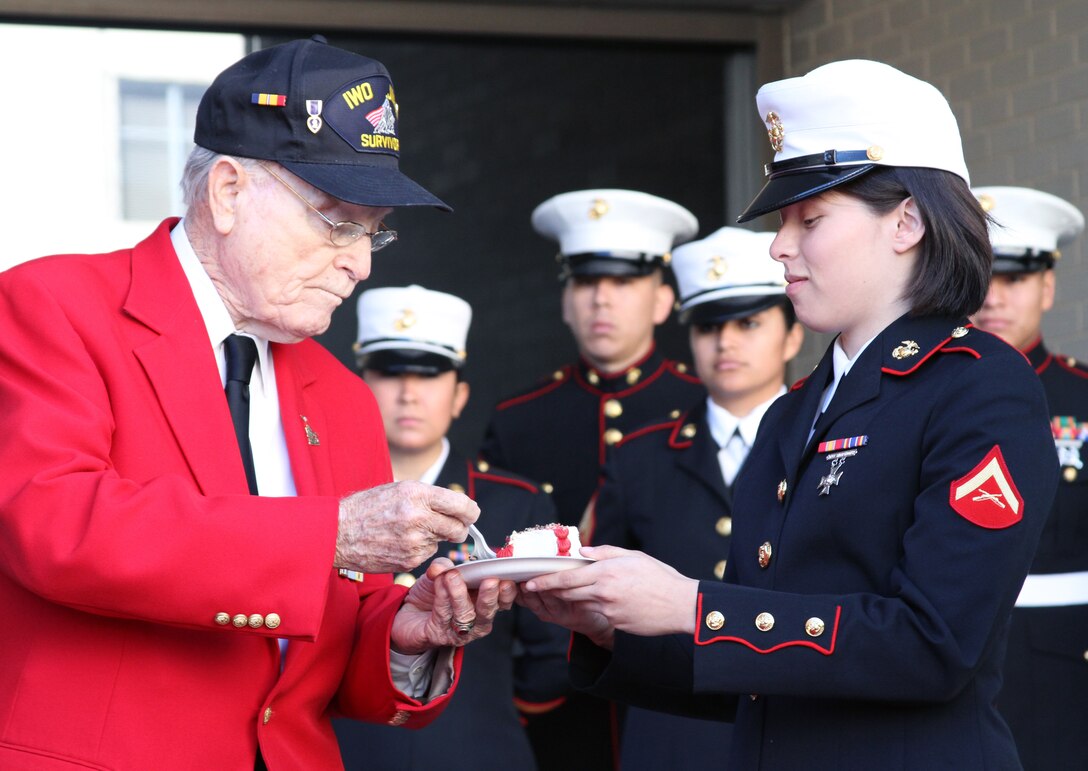 Iwo Jima survivor Lt. Col. George Alden, USAF Ret., passes a piece of cake to Lance Cpl. Jen S. Martinez, a combat correspondent with the 8th Marine Corps District, during the cake cutting portion of the Marine Corps birthday celebration at Fort Worth City Hall on Nov. 10.  Alden was recognized as the oldest Marine present for the ceremony and Martinez was recognized as the youngest, symbolizing the connection between the Corps' past and future.