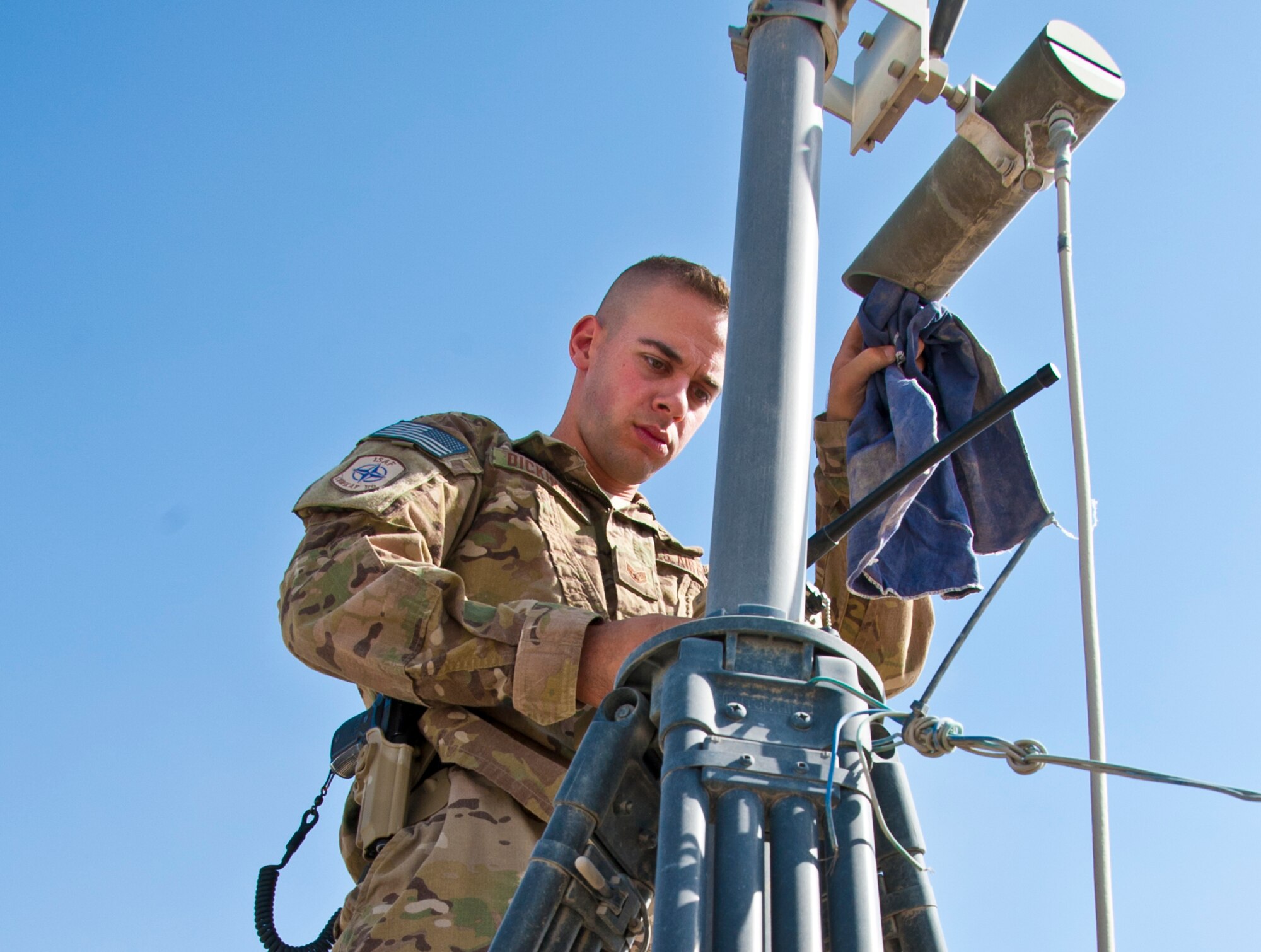 KANDAHAR AIRFIELD, Afghanistan -- Staff Sgt. Alan Dickinson, 451st Air Expeditionary Wing Tactical Automated Security System NCO in charge, cleans off an infrared lens during a routine inspection Oct. 28. Dickinson is deployed from Niagara Falls Air Reserve Station, N.Y. (U.S. Air Force photo by Senior Airman David Carbajal)