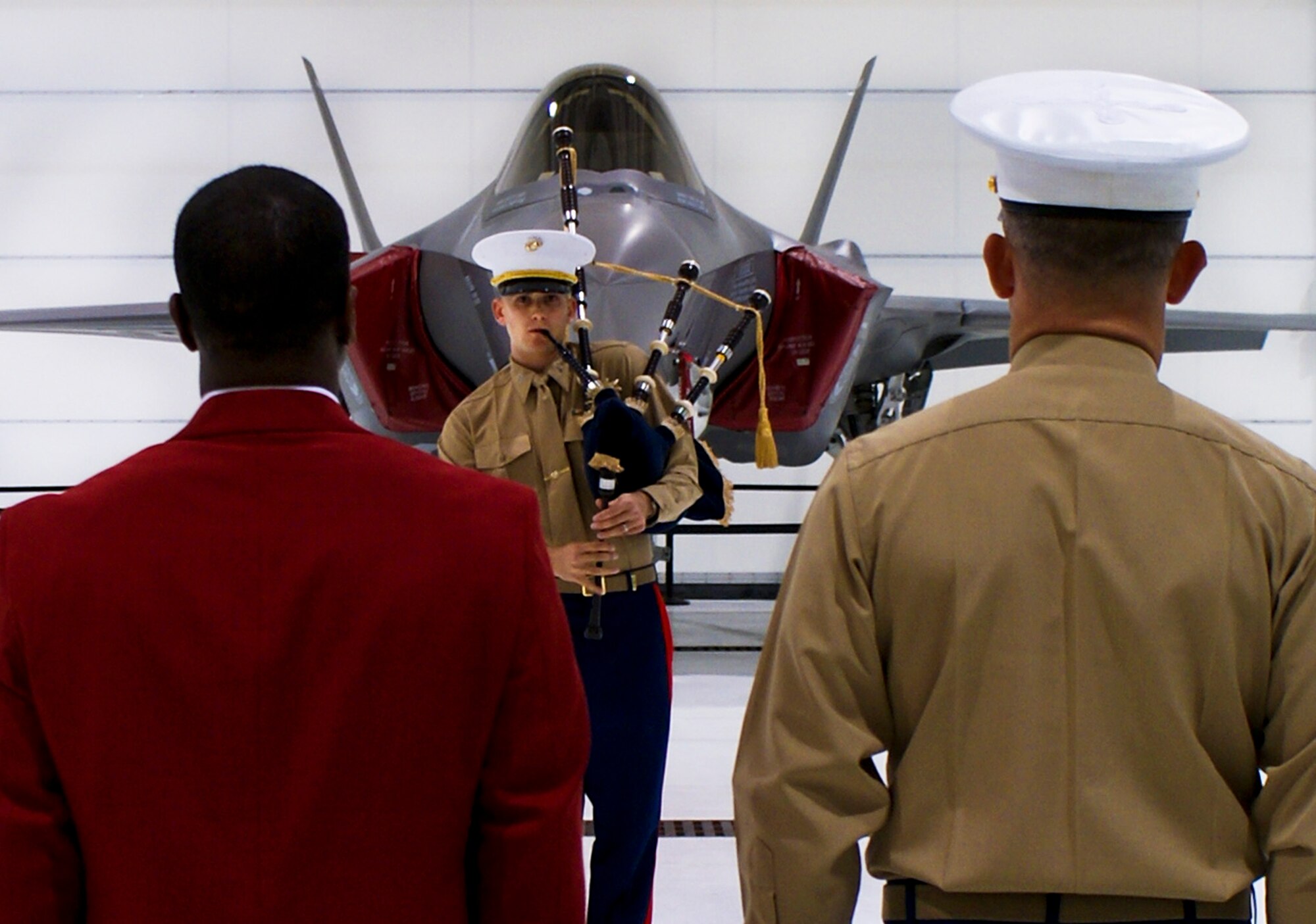 Master Gunnery Sgt. (ret.) Stanley Kennedy and Lt. Col. James Wellons, Marine Fighter Attack Training Squadron 501 commander, stand at attention as 1st. Lt. Michael Harper plays the Marines Hymn on the bagpipes during the Marine Corp birthday cake cutting ceremony Nov. 10 at Eglin Air Force Base, Fla.  The ceremony was held by the men and women of the VMFAT-501. (Photo by Marine Staff Sgt. Stacey Ann Viner)
