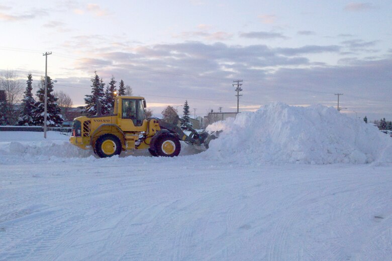 A 673d Civil Engineer Group bucket loader moves snow in a parking lot on Joint Base Elmendorf-Richardson, Wednesday. JBER had 12 inches of snow Sunday. (U.S. Air Force photo/Luke Waack)