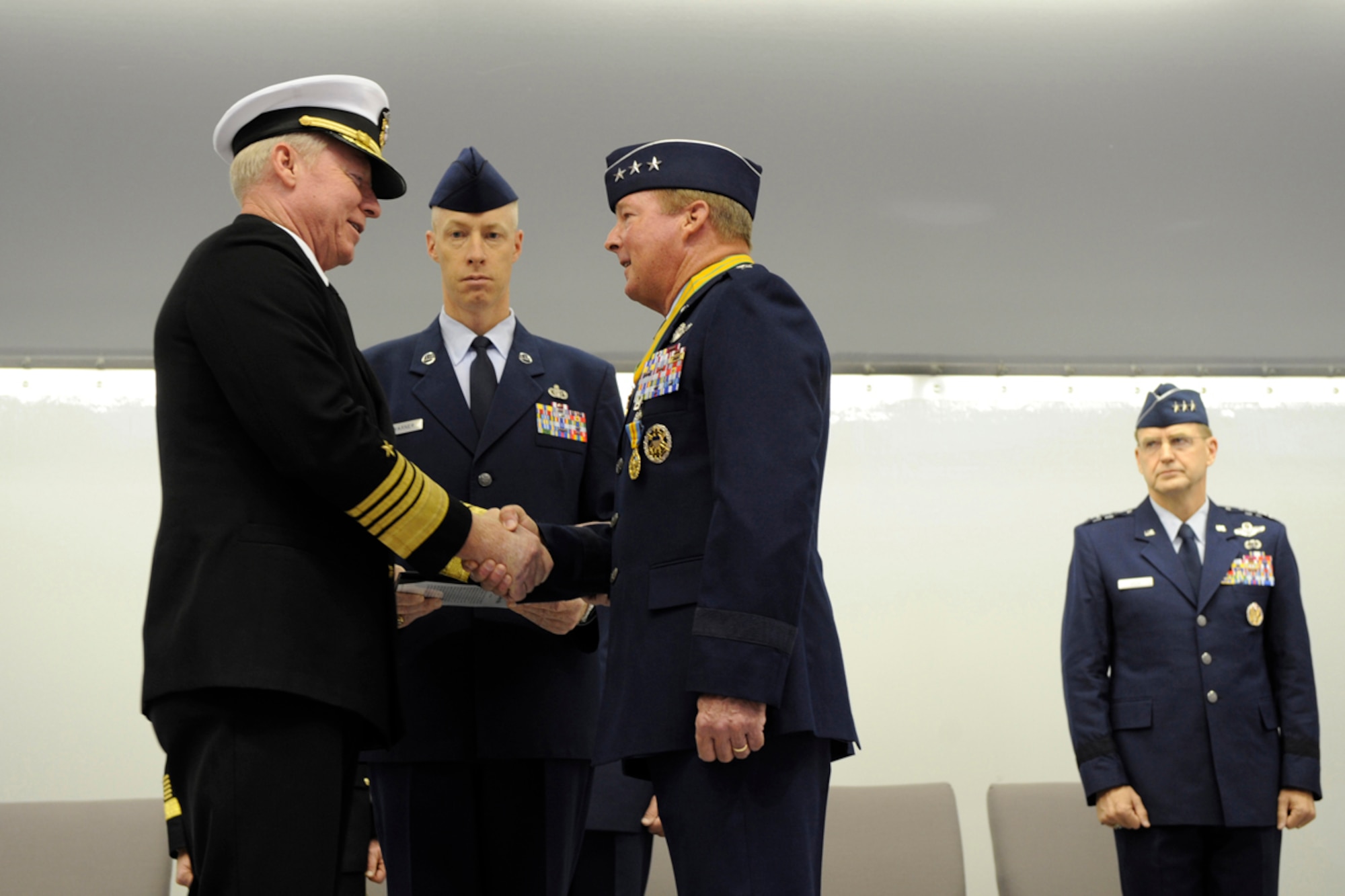 Adm. Robert Willard, commander of Pacific Command, congratulates Air Force Lt. Gen. Dana Atkins after awarding the retiring officer with the Defense Distinguished Service Medal during the Alaskan Command, Eleventh Air Force, Alaskan North American Aerospace Defense Command Region and Joint Task Force Alaska change of command ceremony Nov. 7, 2011. (U.S. Air Force photo/Steven White)