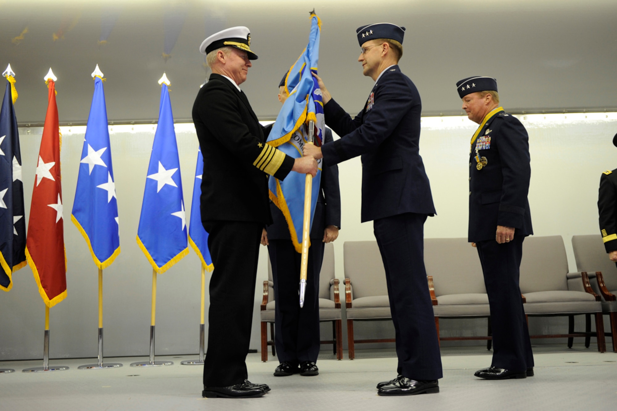 Adm. Robert Willard, U.S. Pacific Command commander, passes the guidon to Lt. Gen. Stephen Hoog, during the Alaskan Command, Eleventh Air Force, Alaskan North American Aerospace Defense Command Region and Joint Task Force Alaska change of command ceremony at Hangar 20 on Joint Base Elmendorf-Richardson, Alaska, Nov. 7, 2011. Hoog assumed the command from Lt. Gen. Dana Atkins. (U.S. Air Force photo/Steve White)