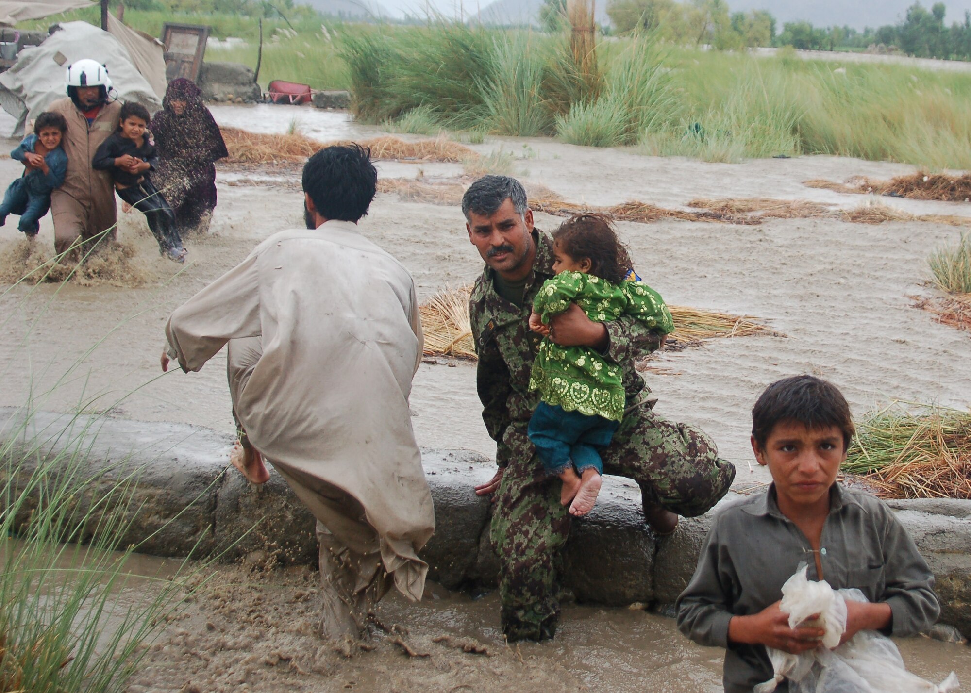 Afghan airmen load passengers onto an Mi-17 helicopter piloted by Lt. Col. Greg Roberts, 19th Air Force, during a rescue mission which lead to the saving of more than 2,000 people over two days. Roberts received the Distinguished Flying Cross with valor for his actions during the rescue in Afghanistan July 28-29, 2010. (Courtesy photo)