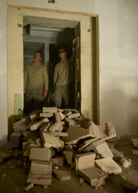 Staff Sgts. Dustin Holmes and Ryan Beaverson, 28th Civil Engineer Squadron structural craftsmen, discuss the next step in clearing a doorway between the new women’s locker room and restroom during a quality of life upgrade project in the Pride Hangar on Ellsworth Air Force Base, S.D., Nov. 1, 2011. Normally a contracted project, the 28th CES is stepping up and taking the lead to complete the renovations as an opportunity to save money and train to support combat operations. (U.S. Air Force photo by Airman 1st Class Kate Thornton/Released)

