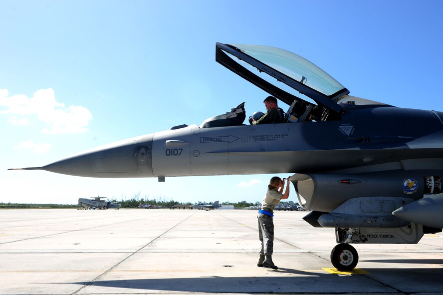 U.S. Air Force Lt. Col. Tom Seymour, above, an F-16 Fighting Falcon pilot assigned to the 46th Test Wing and Senior Airman Paige Nelson, below, assigned to the 46th Aircraft Maintenance Squadron as a crew chief, prepare for a flight in support of Exercise Vigilant Shield 12 at Naval Air Station Key West, Fla., Nov. 6, 2011. The exercise in Key West is the "first-ever proof of concept" for the military's Joint Deployable Integrated Air and Missile Defense System, a collection of high-end radars and missile systems as well as aircraft that work in tandem in the event of a threat to the continental United States.  (U.S. Air Force photo by Staff Sgt. Kamaile O. Long/Released)