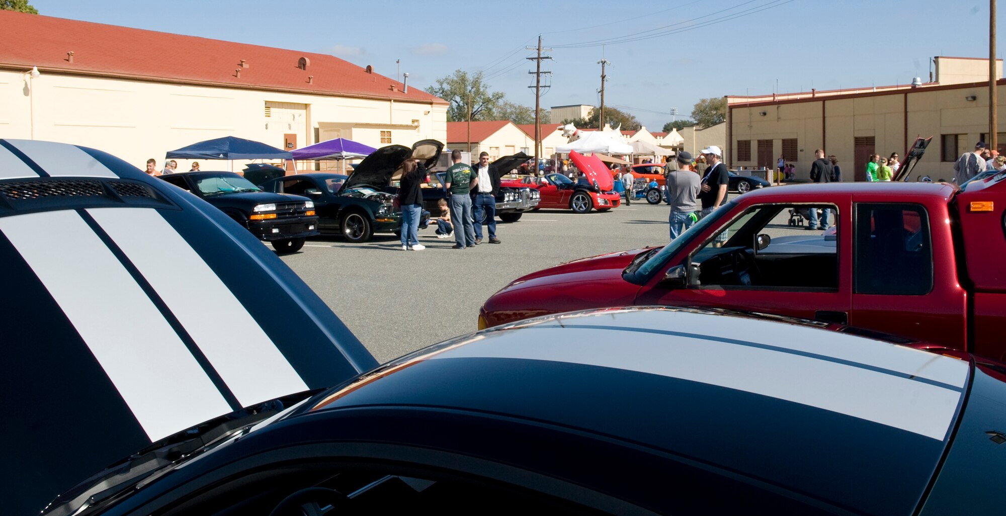 Members of Team Barksdale browse through cars on display at the Fall Festival on Barksdale Air Force Base, La., Nov. 5. The festival showcased cars and motorcycles, and featured shopping booths, arts and crafts, a bounce house and a train ride for children. (U.S. Air Force photo/Airman 1st Class Benjamin Gonsier)(RELEASED)