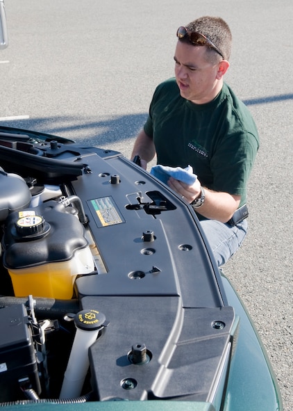 Maj. Matthew Hargis, 2nd Operations Group, works on his car at the Fall Festival on Barksdale Air Force Base, La., Nov. 5. The festival showcased cars and motorcycles, and featured shopping booths,  arts and crafts, a bounce house and a train ride for children. (U.S. Air Force photo/Airman 1st Class Benjamin Gonsier)(RELEASED)