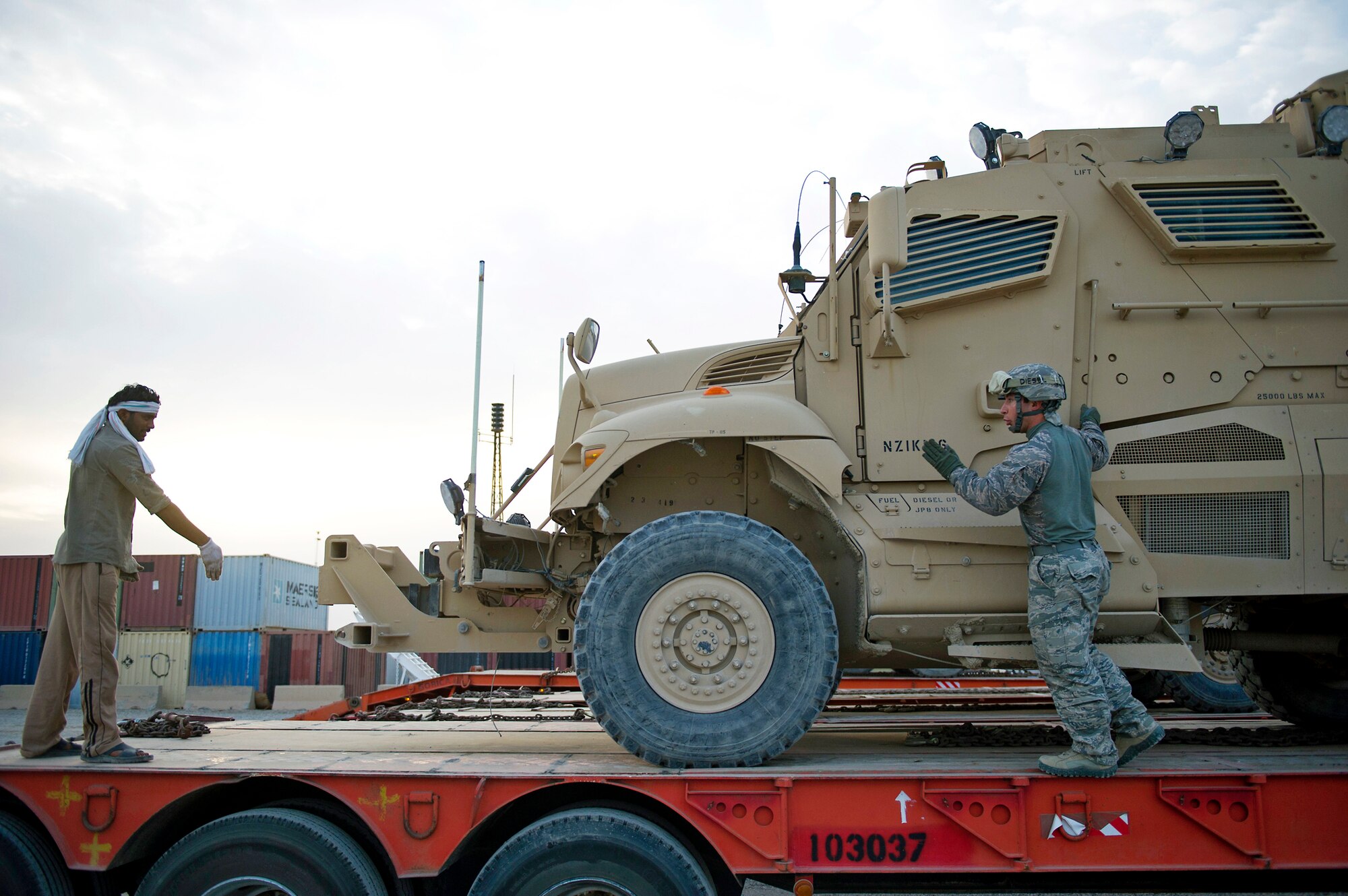 Senior Airman Ryan Baker, with the 70th Medium Truck Detachment, works with a contractor to align a mine-resistant ambush protector on a trailer at Forward Operating Base Warrior on Oct. 27, 2011. Members of the 70th MTD are hauling equipment out of Iraq to meet the deadline for the U.S. military transition from Iraq. (U.S. Air Force photo/Master Sgt. Jeffrey Allen)

