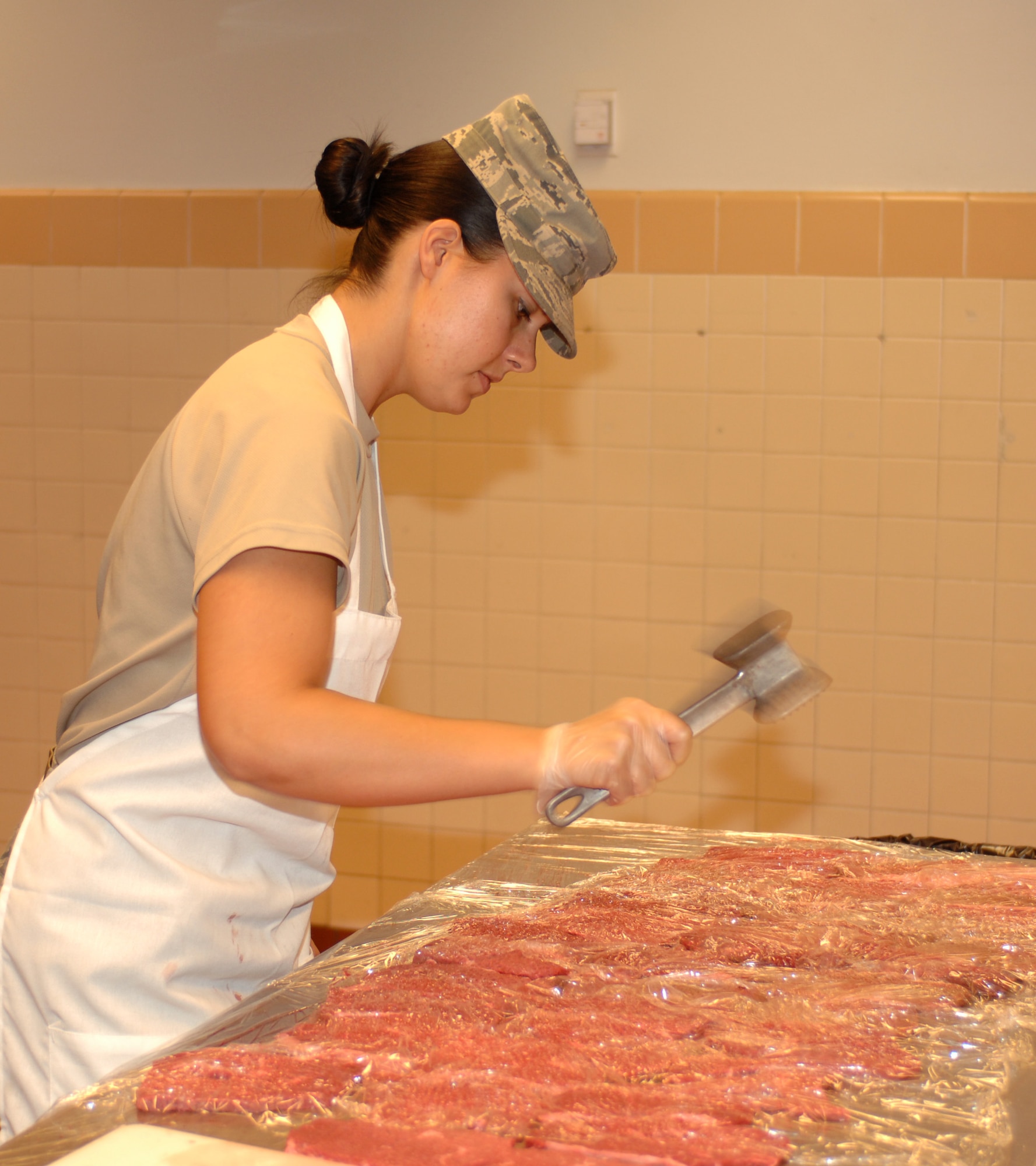 U.S. Air Force Airman 1st Class Ayla McKenna, 355th Force Support Squadron food service apprentice, tenderizes steak with a mallet at the dining facility here at Davis-Monthan Air Force Base, Ariz., Nov. 9. (U.S. Air Force photo by Airman 1st Class Michael Washburn/Released)