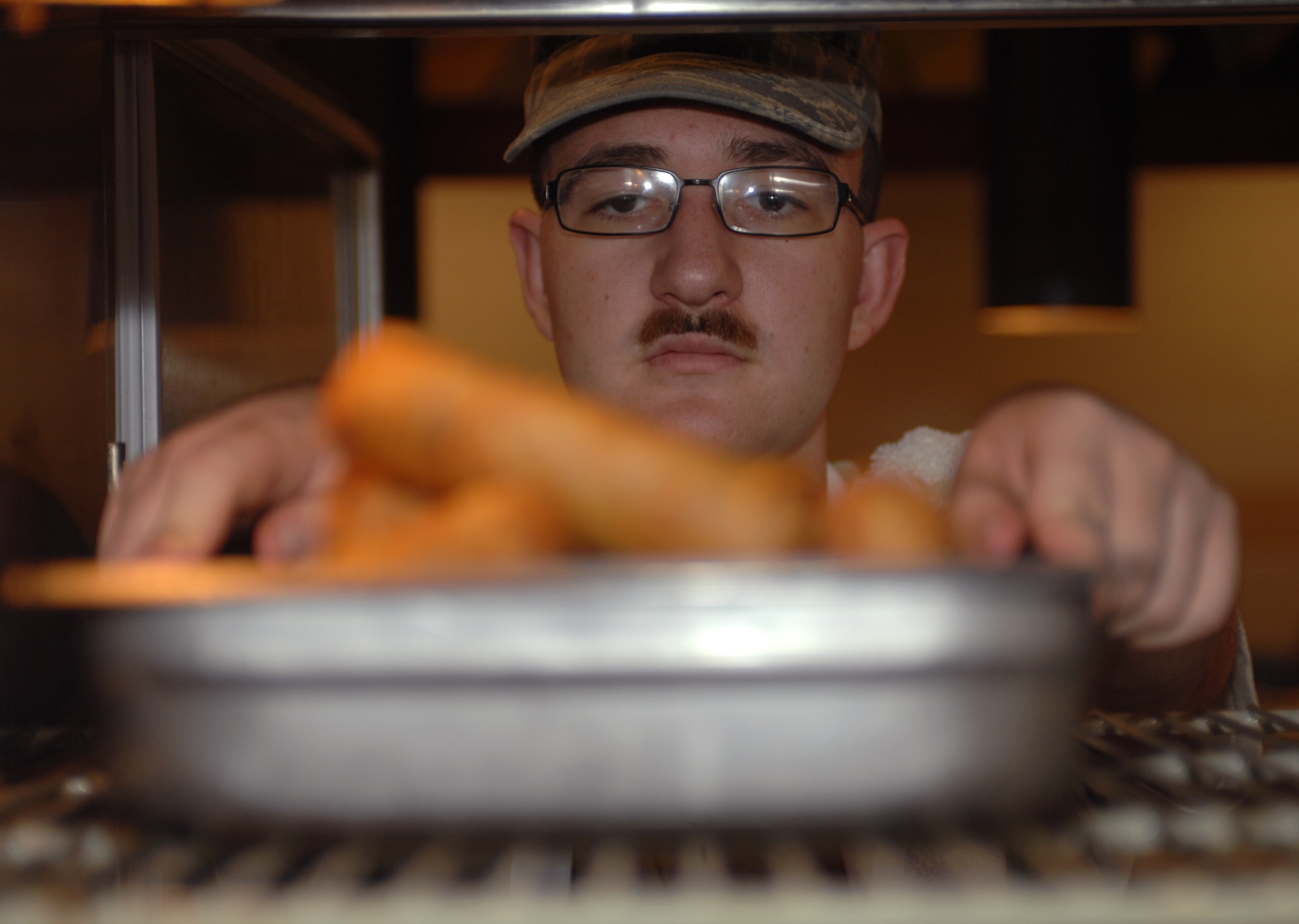 U.S. Air Force Airman 1st Class Cody Vermillion, 355th Force Support Squadron food service apprentice, grabs back-up food from a food-warming unit at the dining facility here at Davis-Monthan Air Force Base, Ariz., Nov. 9. (U.S. Air Force photo by Airman 1st Class Michael Washburn/Released)