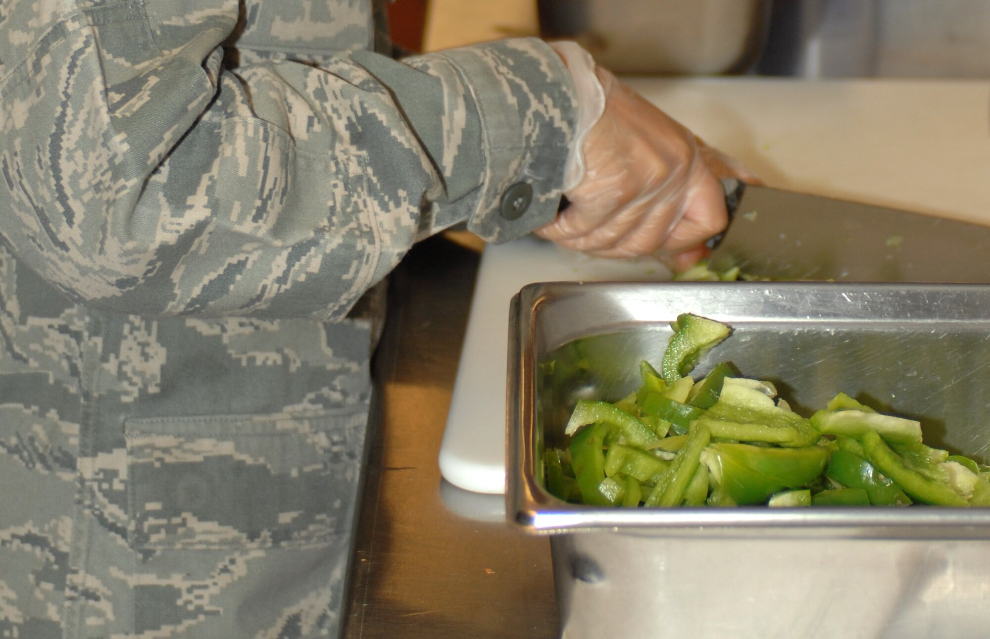 A U.S. Air Force Airman with the 355th Force Support Squadron, chops up green peppers at the dining facility here at Davis-Monthan Air Force Base, Ariz., Nov. 9. (U.S. Air Force photo by Airman 1st Class Michael Washburn/Released)