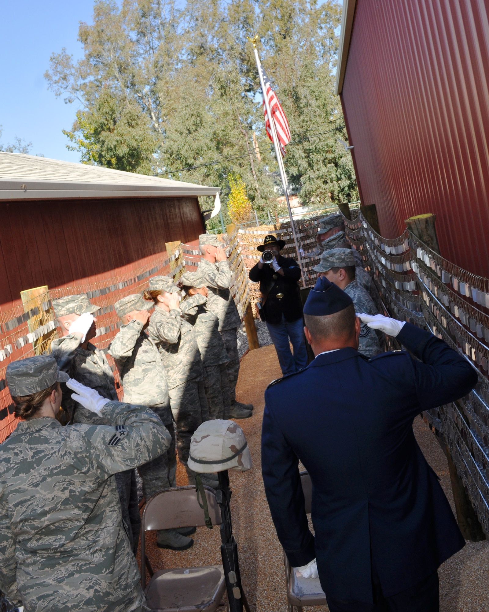 Airmen from Beale Air Force Base, Calif. salute while Tony Pinteo, Vietnam War veteran, plays the bugle during a ceremony at the Museum of the Forgotten Warrior in Marysville, Calif., Nov. 10, 2011.  The ceremony is to honor the opening of the Iraq/Afghanistan Dog Tag Memorial which honors servicemembers lost during the Iraq and Afghanistan Wars.  (U.S. Air Force photo by Staff Sgt. Jonathan Fowler/Released)