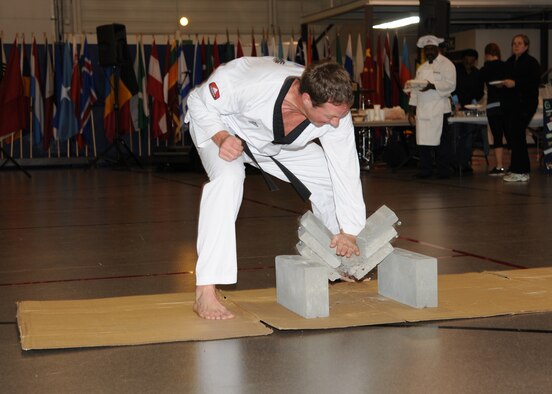 Phil Hebert, member of Championship Taekwondo, crushes cement during a presentation at the Multicultural World Showcase on Nov. 9 on Grand Forks Air Force Base, N.D.  Members of the Grand Forks military community gathered to celebrate their diversity with educational booths, dance and music demonstrations and food from around the world.  (U.S. Air Force photo by Airman 1st Class Ashley N. Taylor)