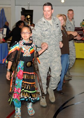 Nelenah Greyeyes leads Col. Tim Bush, 319th Air Base Wing Commander, and other participants in a dance at the Multicultural World Showcase on Nov. 9 on Grand Forks Air Force Base, N.D.  Members of the Grand Forks military community gathered to celebrate their diversity with educational booths, dance and music demonstrations and food from around the world. (U.S. Air Force photo by Airman 1st Class Ashley N. Taylor)