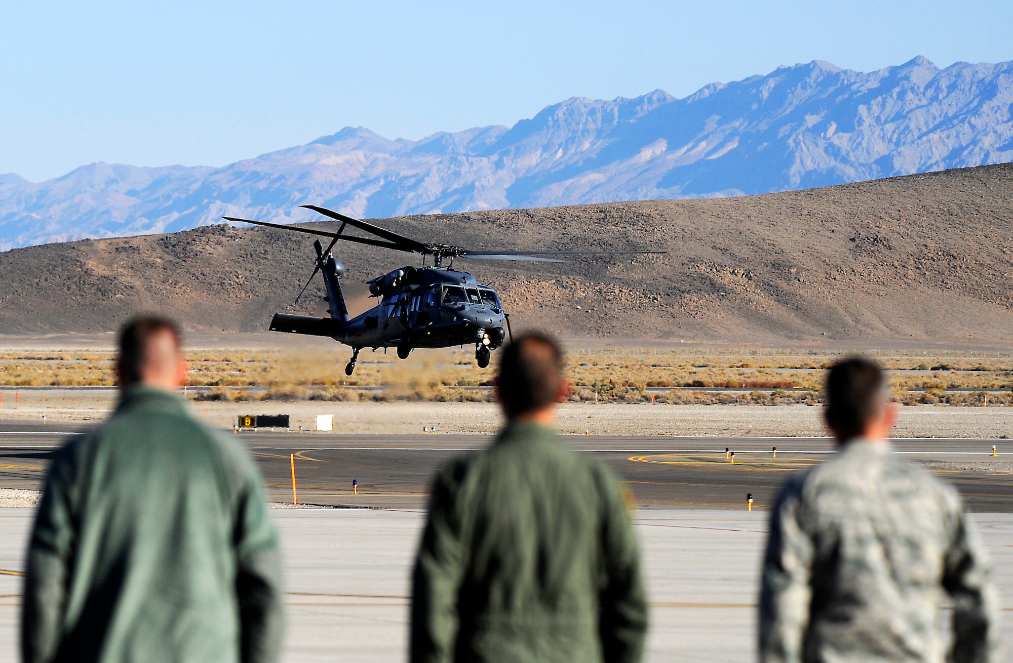 U.S. Airmen at Creech Air Force Base, Nev., stand at attention Nov. 9 as U.S. Air Force Gen. Mike Hostage, commander of Air Combat Command, lands on the runway in an HH-60 Pave Hawk from Nellis AFB, Nev.  Hostage met with the 432nd Wing/Air Expeditionary Wing leadership and Airmen to tour the base and provide direction as the new ACC commander. (U.S. Air Force photo by 432nd AEW Public Affairs/Released)