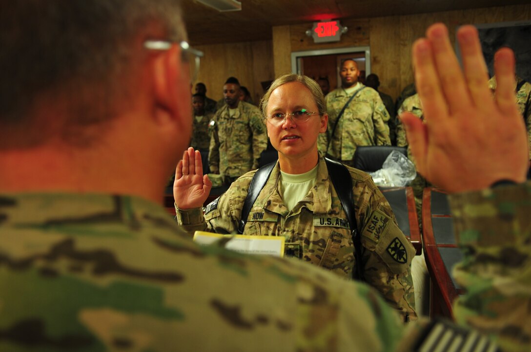 Col. Alan Woodard, foreground, Task Force Resolute deputy commanding officer, issues the oath of office to newly promoted Lt. Col. Victoria Snow, TF-Resolute support operations liaison officer to Forward Operating Base Tarin Kowt, during a promotion ceremony held in the TF-Resolute SPO conference room on Kandahar Airfield, Afghanistan Nov. 1. (U.S. Army photo by Staff Sgt. Alexander Burnett/Released)