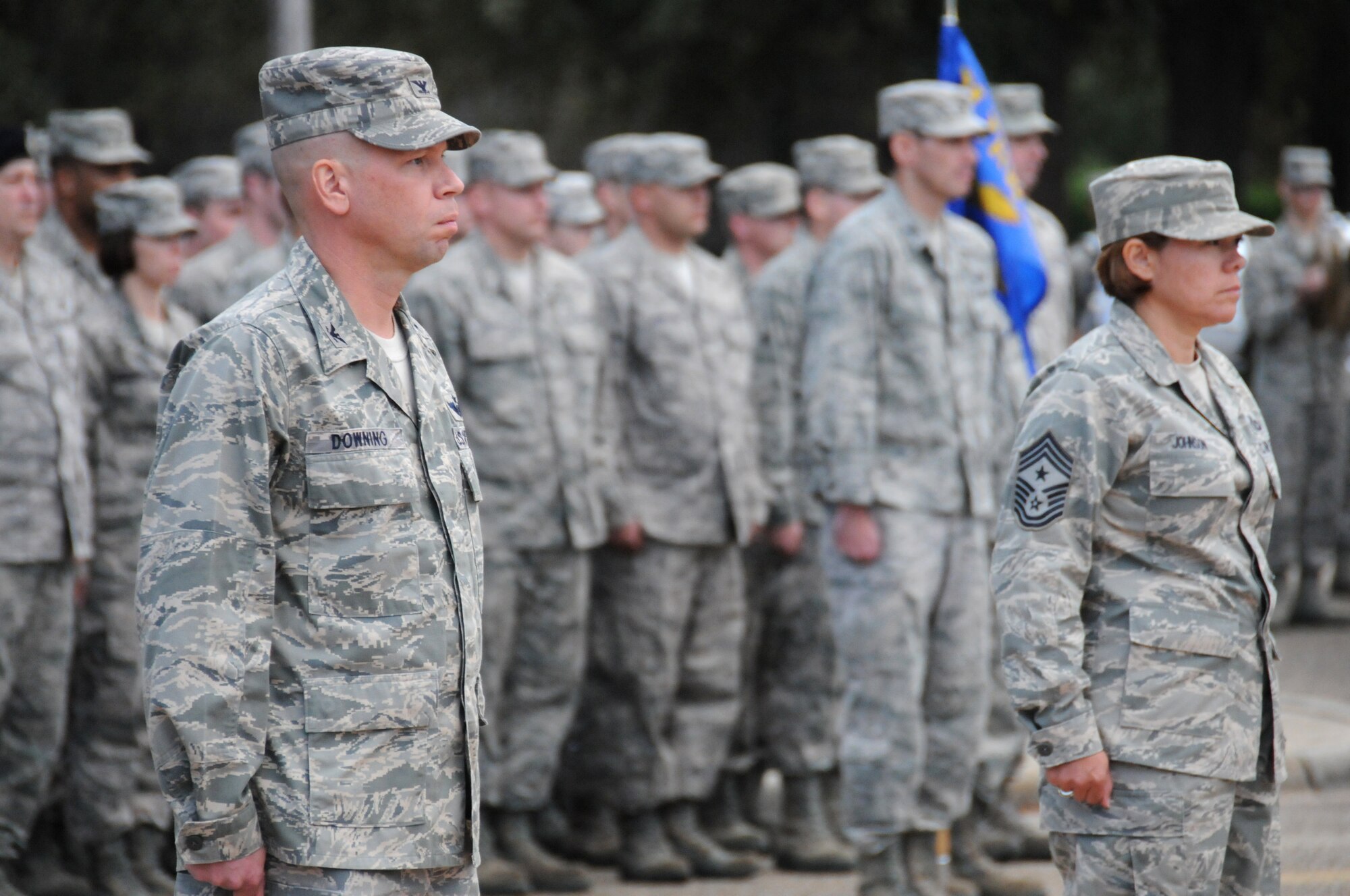 Col. Glen Downing, 81st Training Wing vice commander, and Chief Master Sgt. Angelica Johnson, 81st TRW command chief, stand at attention during a retreat ceremony in front of the wing headquarters’ building at Keesler Air Force Base Nov. 9, 2011.  The retreat was performed in honor of Veteran’s Day.  (U.S. Air Force photo by Kemberly Groue)