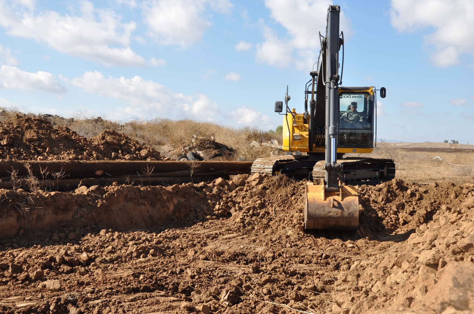 Master Sgt. Jun Prudencio uses a backhoe, Nov. 5, 2011,  to dig one of five mud pits for the Defenders Dash Mud Run scheduled for Nov. 19 at the Ben Clark Joint Training Center, Riverside, Calif.  Prudencio is one of six 452nd Civil Engineer Squadron members helping to prepare the course.  (U.S. Air Force photo/Master Sgt. Linda Welz)