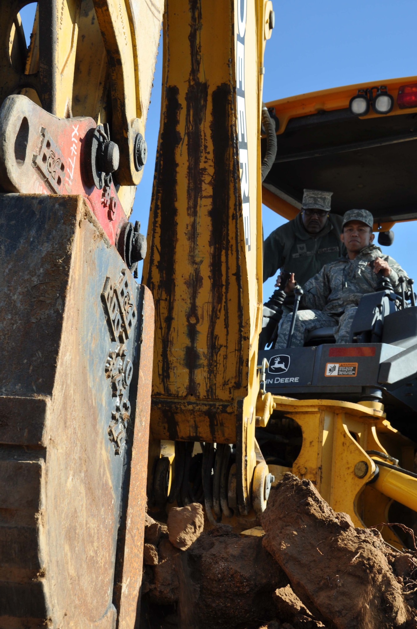 Master Sgt. Jun Prudencio uses a backhoe, Nov. 5, 2011,  to dig one of five mud pits for the Defenders Dash Mud Run scheduled for Nov. 19 at the Ben Clark Joint Training Center, Riverside, Calif., as Tech. Sgt. Jeffrey West observes.  Prudencio and West are two of six 452nd Civil Engineer Squadron members helping to prepare the course.  (U.S. Air Force photo/Master Sgt. Linda Welz)