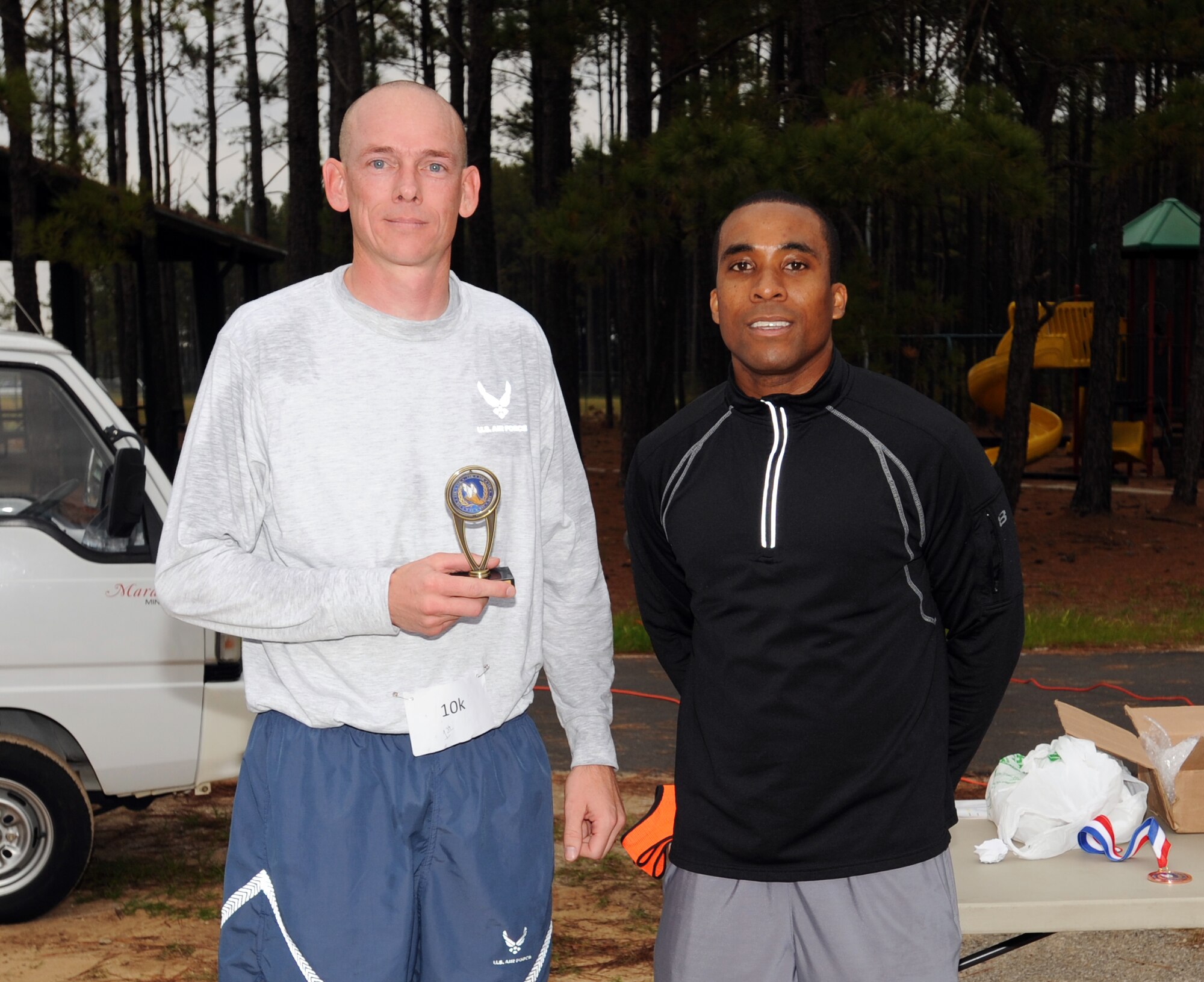 U.S. Air Force Staff Sgt. Perris Coleman, 20th Equipment Maintenance Squadron unit fitness program manager, awards Tech. Sgt. Stephan Hunter, 20th Security Forces Squadron standard evaluation, with the first place trophy upon his completion of the 10K Combined Federal Campaign run, Shaw Air Force Base, S.C., Nov. 10, 2011. This year is "50 years of caring" for the CFC. CFC is an annual drive which is based on one idea for one gift, once a year. Its purpose is to "improve quality of local community, nation, and world," President John F. Kennedy 1961. This year's goal is to reach $175,000. (U.S. Air Force photo by Airman 1st Class Tabatha Duarte/Released)