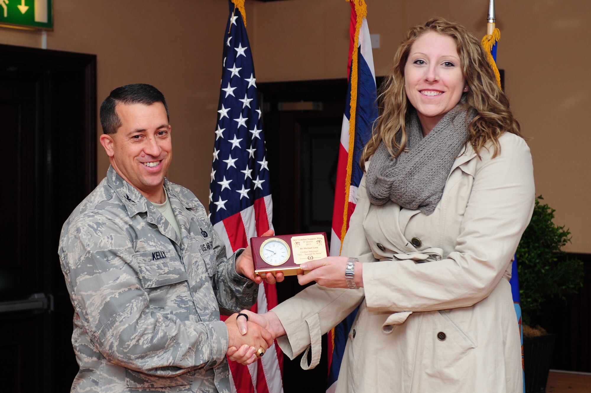 RAF MENWITH HILL, United Kingdom - Amber Cornett accepts an award on the behalf of Michael Leeks, who was recognized by the 501st Combat Support Wing as the Civilian Volunteer Third Quarter Award winner. (U.S. Air Force photo by Senior Airman Joel Mease)