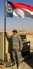 Tech. Sgt. Michael Joyner, a reservist with the 567th RED HORSE Squadron, stands next to a small piece of home during a recent deployment. (USAF photo courtesy of 567RHS)