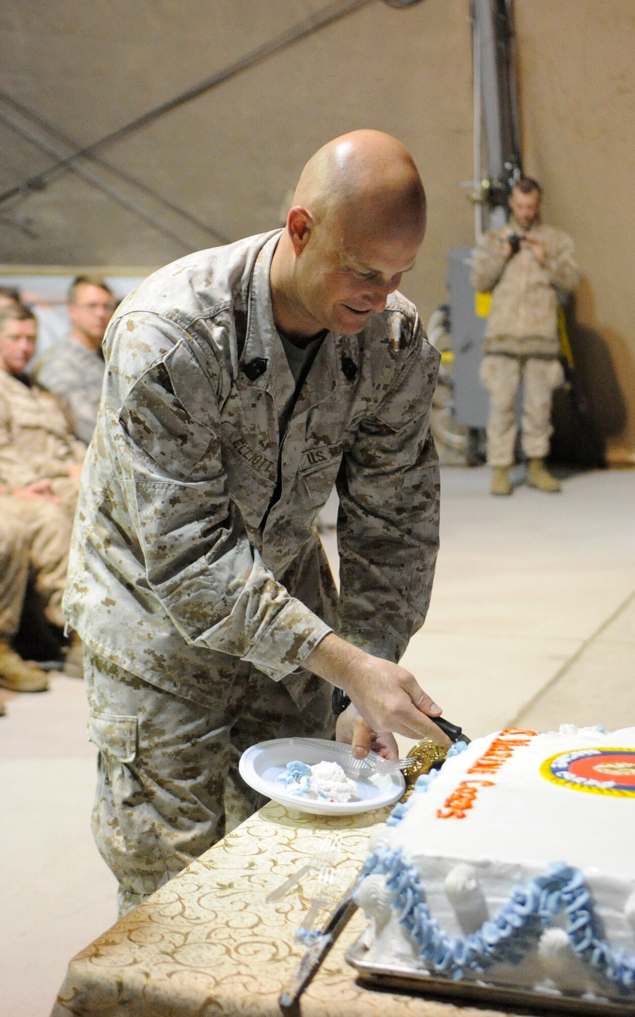 Master Gunnery Sgt. Anthony Elliott serves the first piece of the the Marine Corps’ birthday cake during a ceremony celebrating the Corps’ 236th birthday at the Transit Center at Manas, Kyrgyzstan, Nov. 10. It is tradition for the birthday celebration’s special guest to receive the first bite of cake, followed by the oldest and youngest Marines on the installation. (U.S. Air Force photo/Tech. Sgt. Tammie Moore)