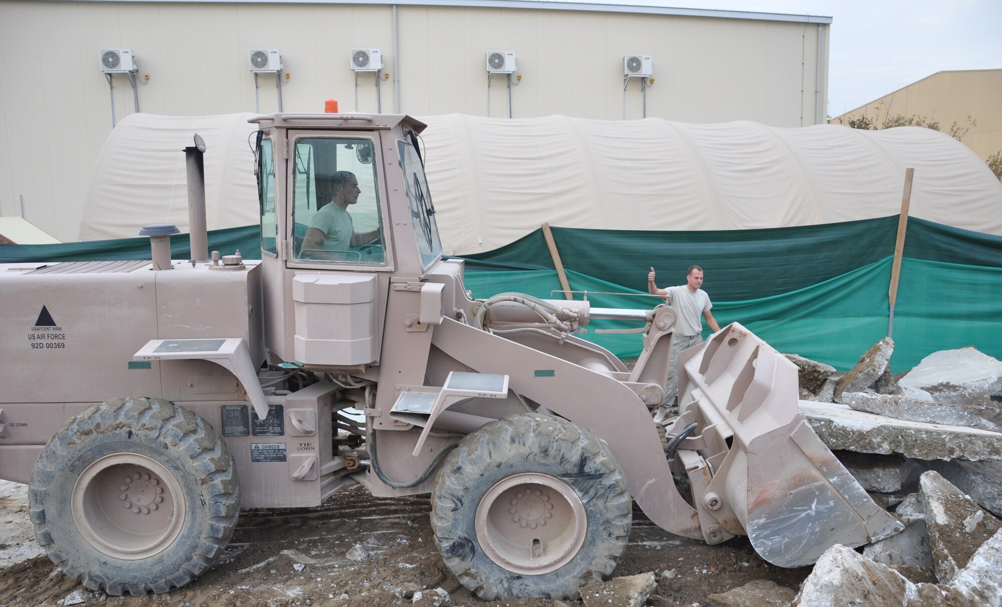 Airmen from the 455th Expeditionary Civil Engineer Squadron clean up debris from a recently demolished building to make way for a new security forces facility. CE personnel and defenders from the 455th Expeditionary Security Forces Squadron are working side by side to complete the construction process and provide improved facilities for Bagram’s Airmen. (U.S. Air Force photo/Staff Sgt. John Wright)