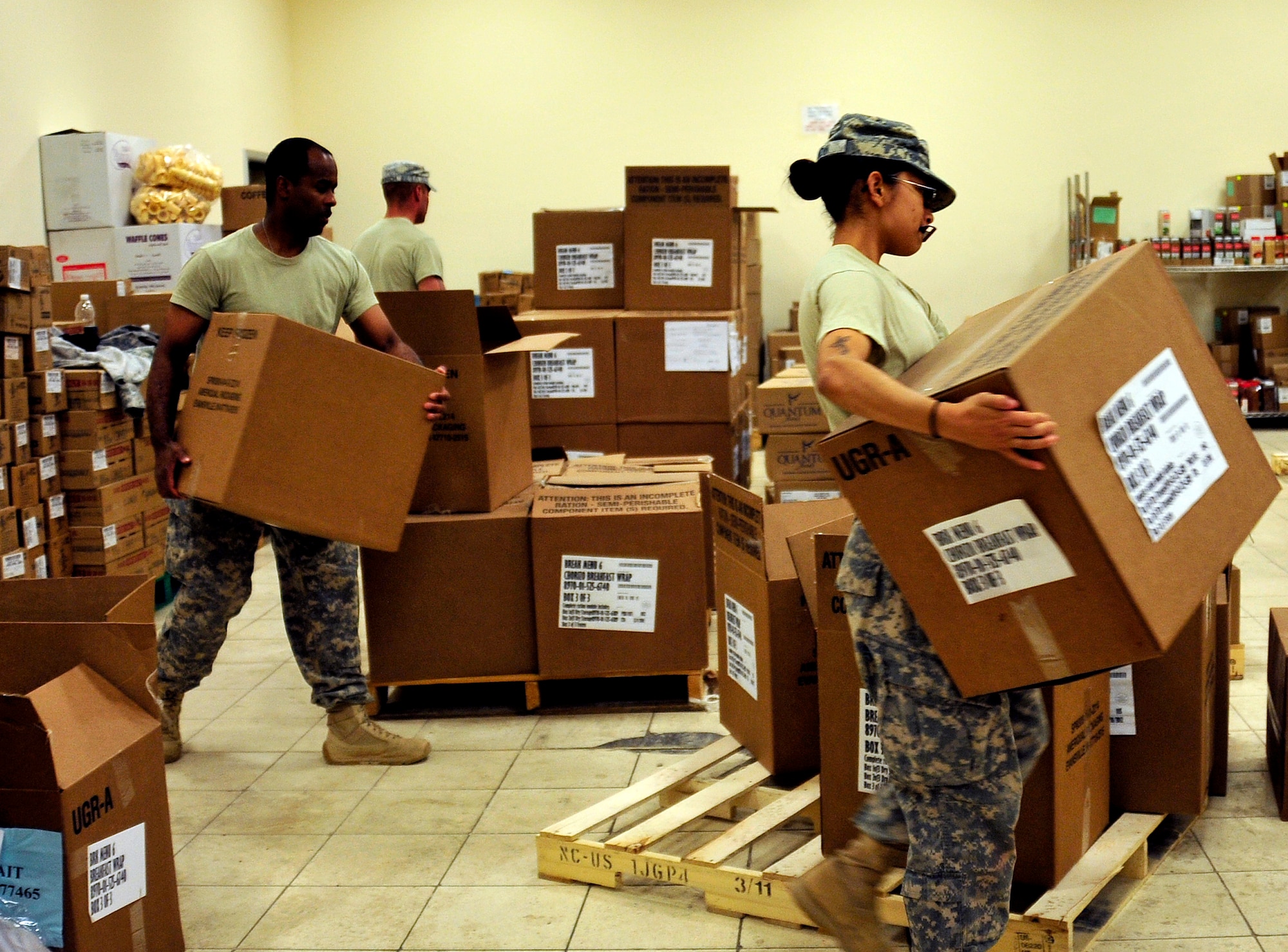 Army Spc. Marisol Landin, health care specialist, right, Staff Sgt. Christopher Middlebrooks, laundry and showers NCO, left, and Spc. Theodore Gigrich, wheeled vehicle mechanic, organize boxes of food at the dining facility at Joint Base Balad, Iraq, Oct. 15, 2011.  With the release of food services contractors, Airmen and soldiers joined together at the dining facility to feed the troops during the closure of JB Balad.    JB Balad has disassembled units, turned in equipment, and shut down services to transition the base to the Iraqi government. Landin is deployed from Fort Hood, Texas, and is from Jacksonville, Texas.  Middlebrooks is deployed from Joint Base McGuire-Dix-Lakehurst, N.J., and is from Edgewater Park, N.J. Gigrich is deployed from Fort Hood and is from Kalispell, Mont.  (U.S. Air Force photo/Master Sgt. Cecilio Ricardo)