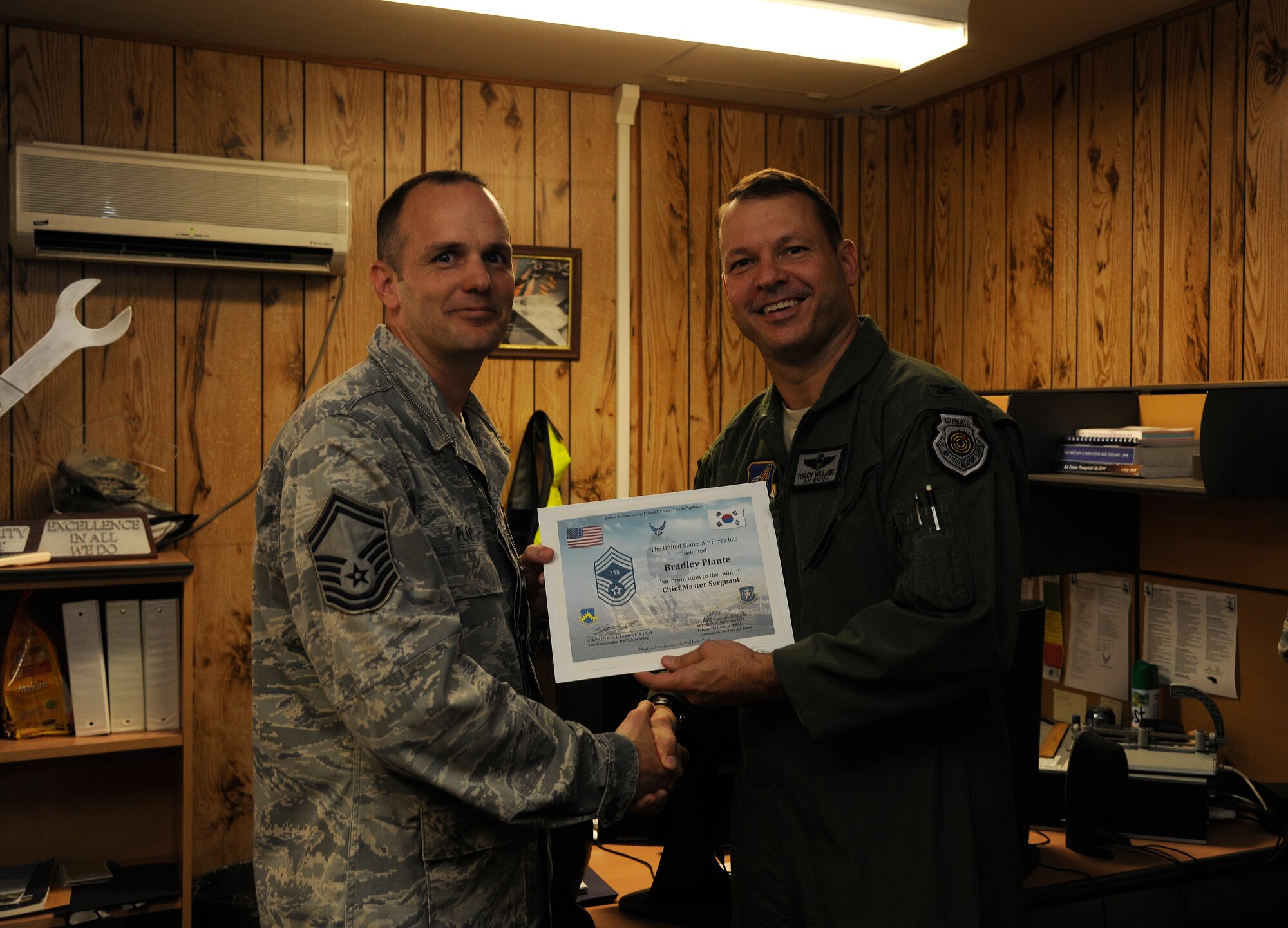 Col. Stephen Williams, 8th Fighter Wing vice commander, congratulates Senior Master Sgt. Bradley Plante, 8th Maintenance Squadron, on his selection for promotion to chief master sergeant at Kunsan Air Base, Republic of Korea, on Nov. 3, 2011. (U.S. Air Force photo by Staff Sgt. Rasheen Douglas/Released)