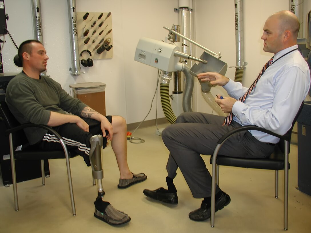 Prosthetic department colleagues Scott Gray and Tristan Wyatt converse at the San Diego VA Medical Center’s prosthetic limb machinery shop. Wyatt, who is assistant chief of prosthetics at the VA San Diego Healthcare System, is helping other veterans recover from traumatic injuries. VA Photo by Christopher Menzie 