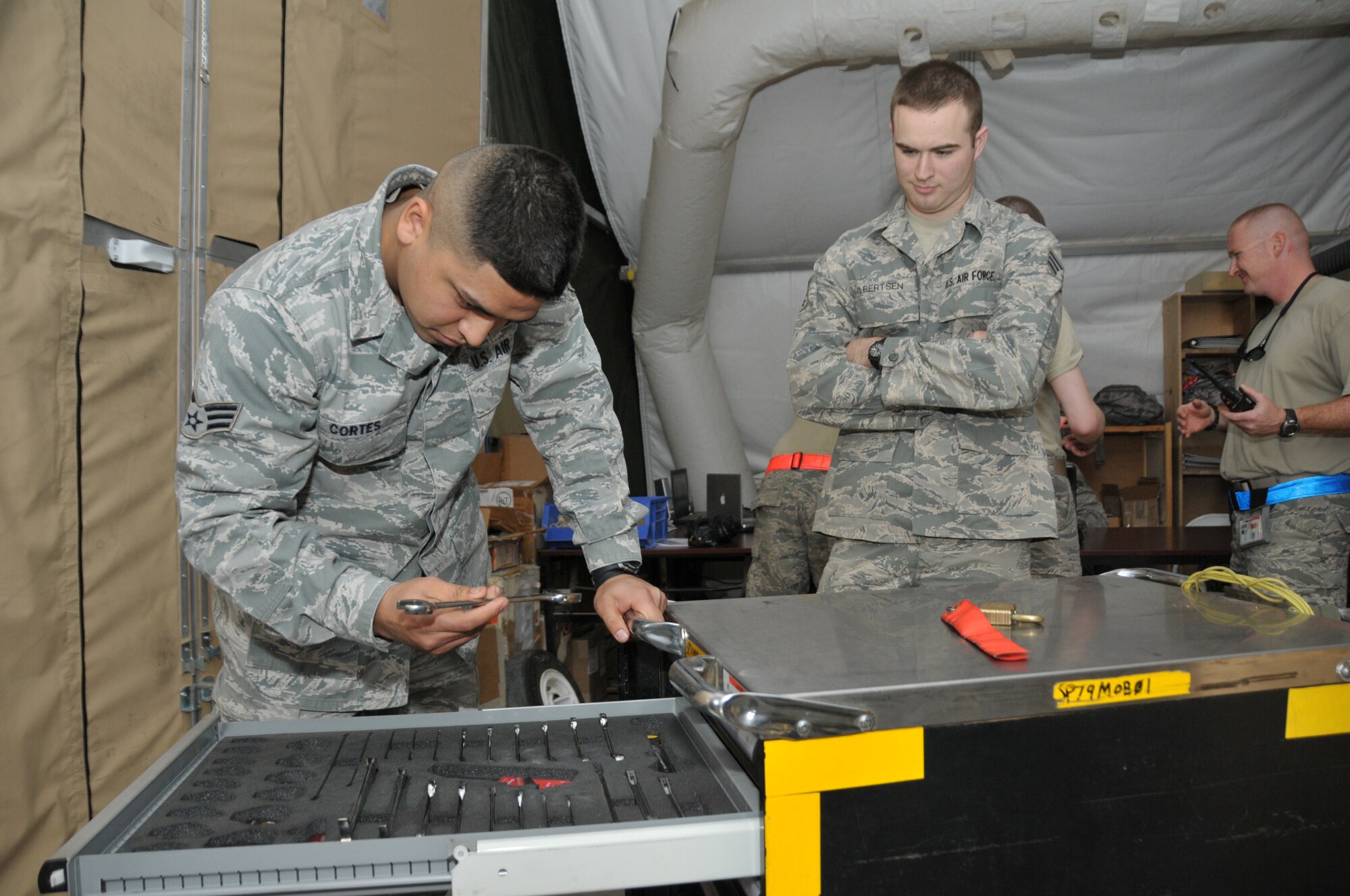 Senior Airman Steven Cortes and Senior Airman Jon Albertsen III, both 332nd Expeditionary Aircraft Maintenance Squadron support technicians, check in an F-16 tool kit inside the maintenance control tent at an undisclosed location in Southwest Asia Nov. 8, 2011. The facility used by Cortes and Albertsen, who are both deployed from Shaw Air Force Base, N.C., uses discarded storage lockers and dormitory lockers to store tools and other maintenance equipment.  (U.S. Air Force photo by Master Sgt. Paul Mann)
