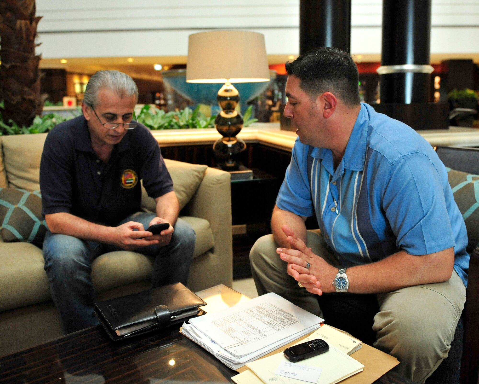 Tech. Sgt. Ian Black, the contracting officer for the 380th Expeditionary Contracting Squadron, goes over a contract for lodging arrangements for U.S. participants in the Dubai Airshow 2011 with Mr. Halim Droubi, the director of sales for one of the participating hotels. Black acts a liaison for all contracts and vendors for U.S. participants in the air show. The air show will highlight a variety of U.S. Air Force, Navy and Army aircraft showcasing the range of U.S. military airpower capabilities. Aircrew and support personnel from bases in the gulf region, Europe and the U.S. are participating in the event, which is expected to draw more than 55,000 visitors. (U.S. Air Force photo/Tech. Sgt. Patrick Mitchell)