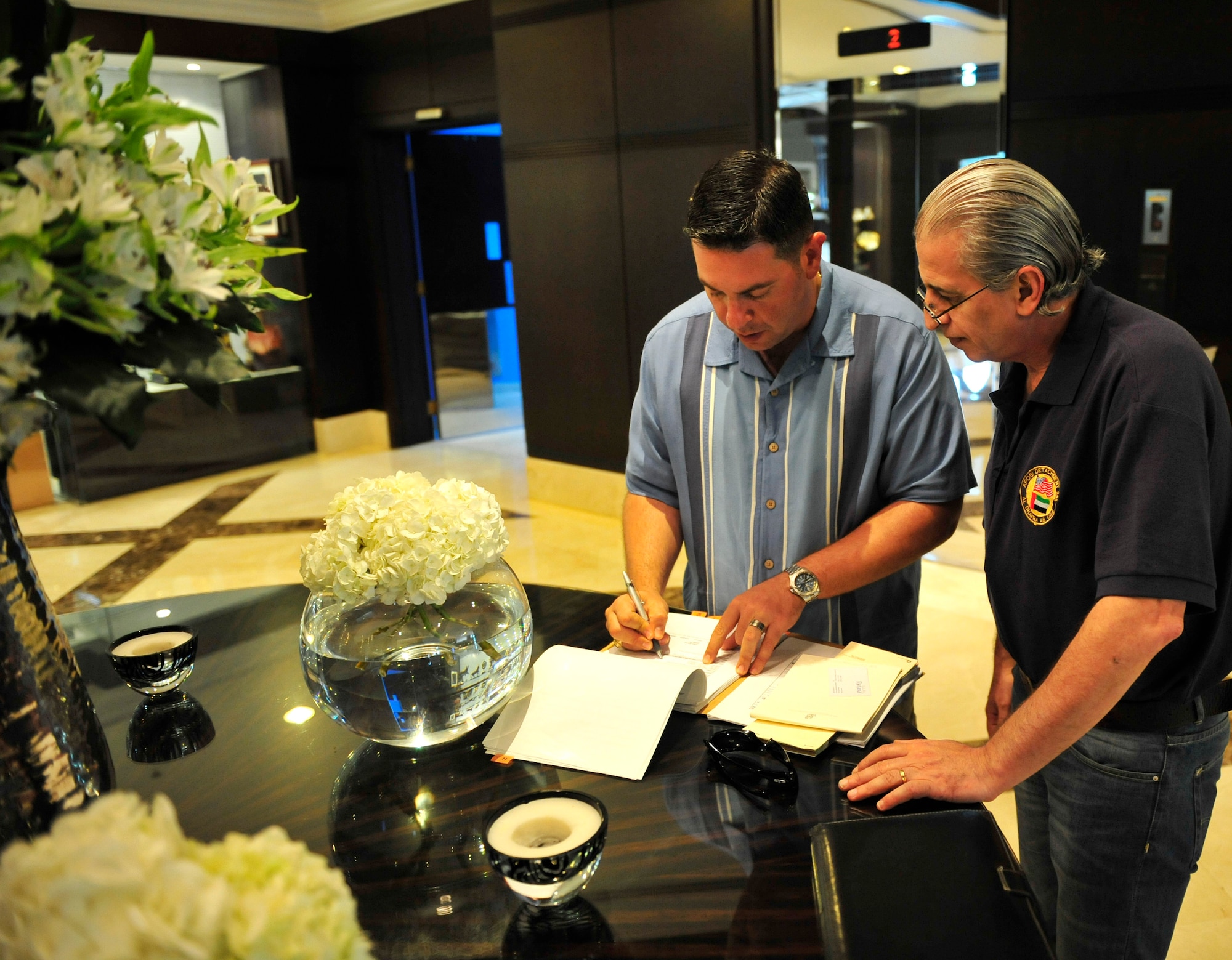 Tech. Sgt. Ian Black, the contracting officer for the 380th Expeditionary Contracting Squadron, goes over a contract for lodging arrangements for U.S. participants in the Dubai Airshow 2011 with Mr. Halim Droubi, the director of sales for one of the participating hotels. Black acts a liaison for all contracts and vendors for U.S. participants in the air show. The air show will highlight a variety of U.S. Air Force, Navy and Army aircraft showcasing the range of U.S. military airpower capabilities. Aircrew and support personnel from bases in the gulf region, Europe and the U.S. are participating in the event, which is expected to draw more than 55,000 visitors. (U.S. Air Force photo/Tech. Sgt. Patrick Mitchell)