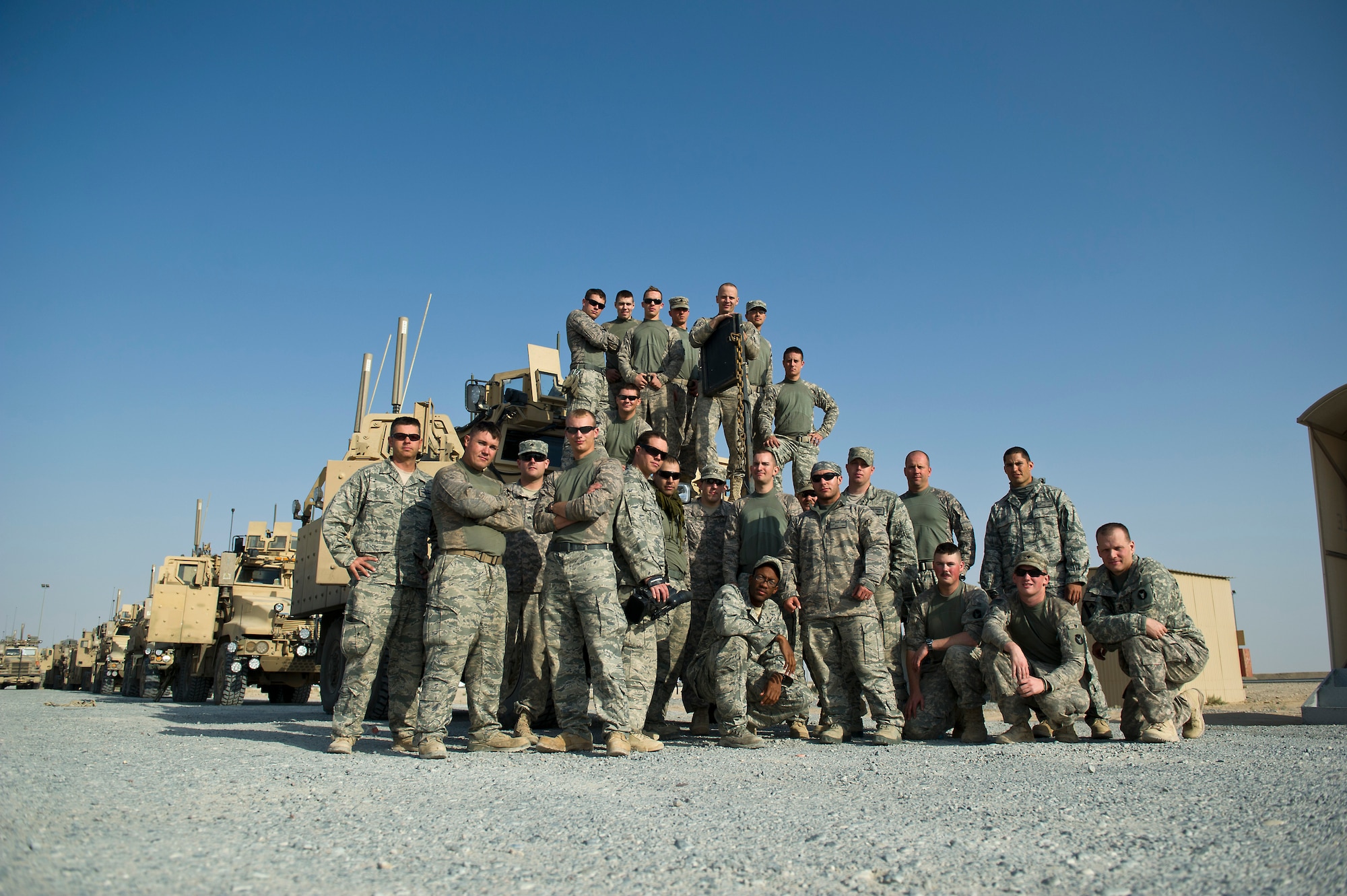 U.S. Air Force members assigned to the 70th medium truck detachment and U.S. Army Minnesota National Guard members assigned to B-Troop, 1-94 Cavalry, Pine City MN, pose for a group photo after successfully transporting equipment out of Iraq on Oct. 30, 2011. The Joint team drove more than 1,100 miles and hauled 43 truckloads of supplies and equipment out of Iraq. The 70th MTD runs the convoy operations while B-Troop provides security. (U.S. Air Force Photo/Master Sgt. Jeffrey Allen)