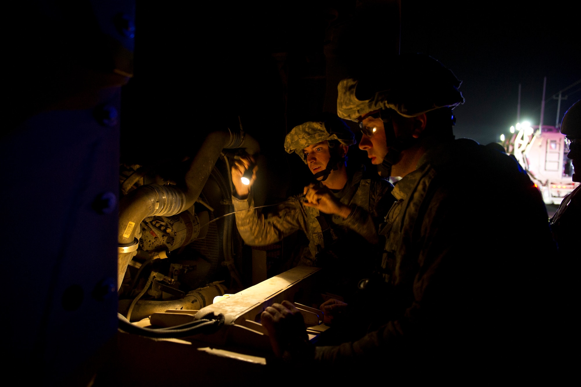 U.S. Air Force Master Sgt. Gary Ferreri (right) a Philadelphia, PA. native, and Senior Airman Christopher Barton, a Las Vegas native assigned to the 70th medium truck detachment, inspect the engine of a a truck that caught on fire while traveling in a high threat area of Iraq on Oct. 26, 2011. Ferreri and Barton quickly determined the cause of the fire to be a blown turbo charger which required the truck to be towed. Rapid assessments and repairs are critical due to the high threats faced by convoys stopped on Iraqi roads. (U.S. Air Force Photo/Master Sgt. Jeffrey Allen)