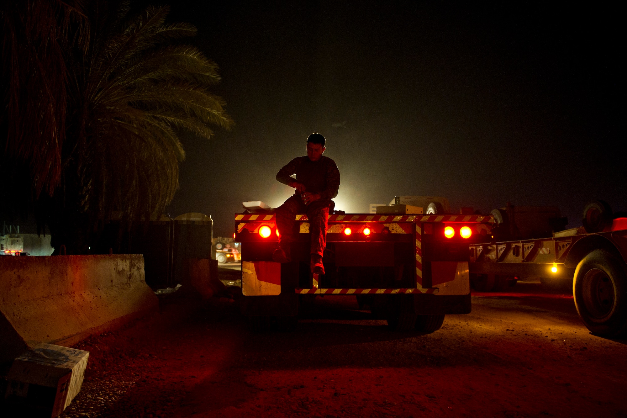U.S. Air Force Airman 1st Class, Tyler Bartlett 70th medium truck detachment, eats dinner on a truck trailer at Kalsu, Iraq on Oct. 26, 2011. Bartlett, who is two weeks into his first deployment, is a vehicle operator in convoy of 43 vehicles and 60 passengers traveling more than 1,100 miles through Iraq. Members of the 70th MTD are hauling equipment out of Iraq to meet the deadline for the U.S. military transition from Iraq. (U.S. Air Force Photo/Master Sgt. Jeffrey Allen)