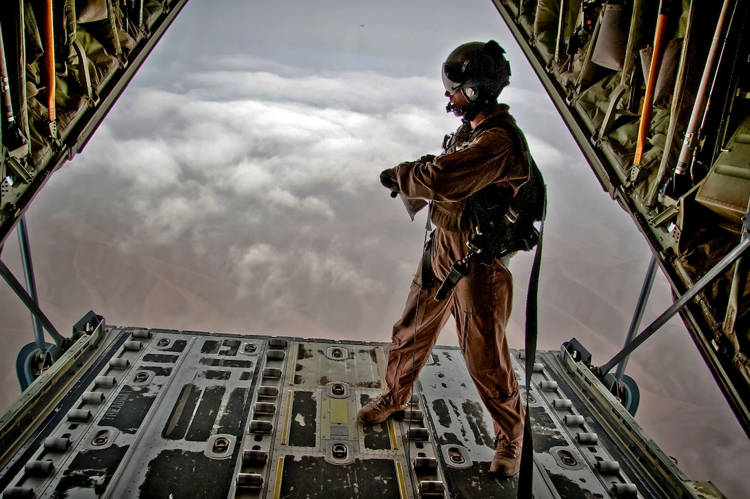 U.S. Air Force Tech. Sgt. Gabriel Campbell looks out on the bay of a C-130J Hercules aircraft before releasing pallets of cargo during an airdrop over Afghanistan, Nov. 7, 2011. Campbell is a load master assigned to the 772nd Expeditionary Airlift Squadron.