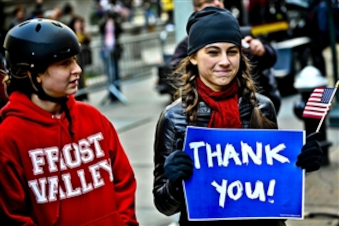 A young lady holds up a sign thanking military veterans at the Veterans Day Parade in New York, Nov. 11, 2011.
