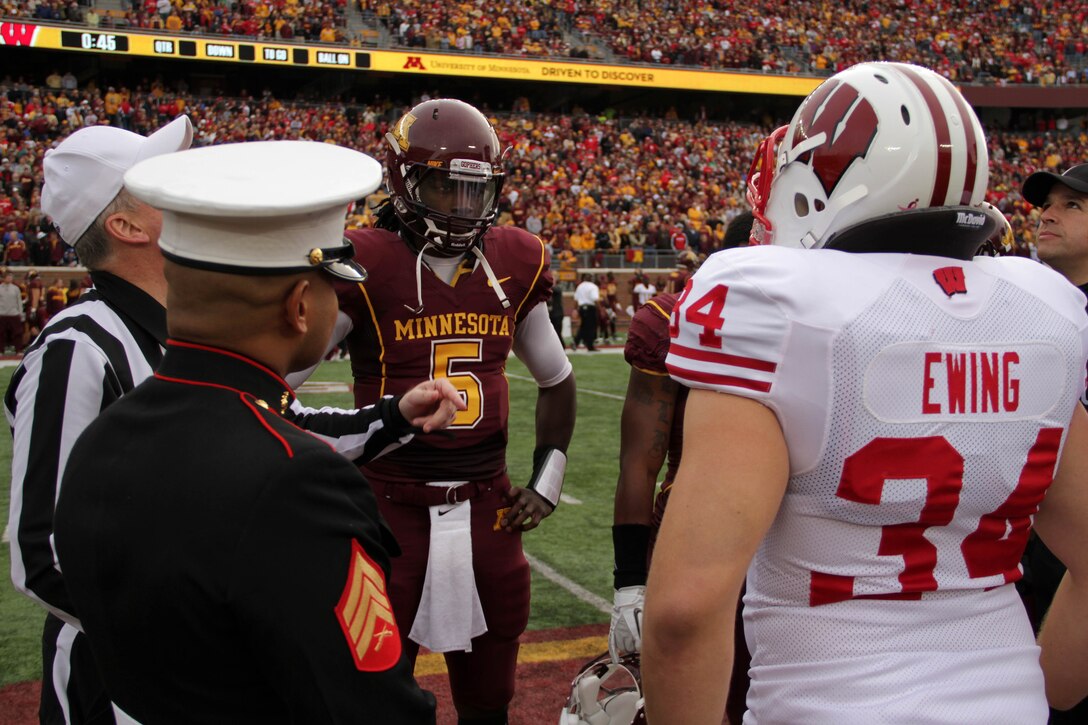 Sgt. Van Tulmau, who served with 2nd Battalion, 5th Marine Regiment, waits for the coin toss to land during the Golden Gophers and Wisconsin Badgers matchup Nov. 12. University of Minnesota officials named Sgt. Van Tulmau an honorary co-captain for the game in honor of Veteran’s Day. For additional imagery from the event, visit www.facebook.com/rstwincities.