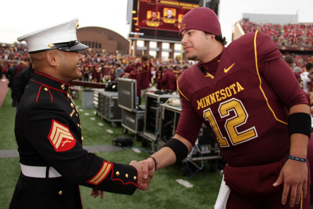 Sgt. Van Tulmau shakes hands with Golden Gopher Quarterback Moses Alipate before the opening kickoff of the University of Minnesota and Wisconsin Badgers football game Nov. 12. Tulmau was named an honorary co-captain for the game in honor of Veteran’s Day. For additional imagery from the event, visit www.facebook.com/rstwincities.