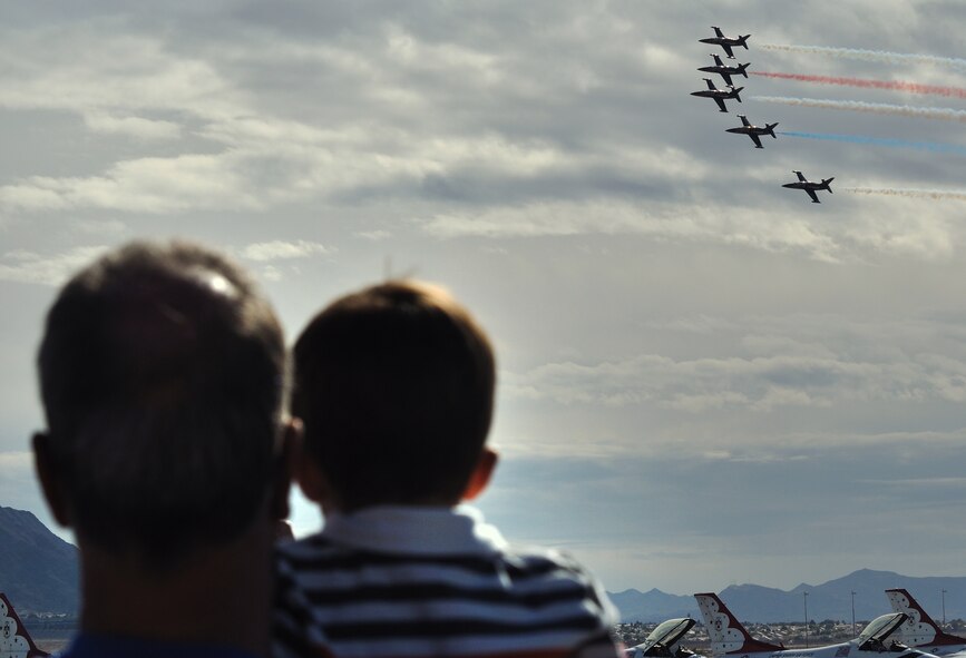 Father and son watch the sky as the Patriots Demonstration Squadron, fly overhead during the 2011 Aviation Nation Open House Nov. 12, at Nellis Air Force Base, Nev. Aviation Nation celebrates 70 years of airpower in Las Vegas and the Air Force's accomplishments in air, space and cyberspace. (U.S. Air Force photo by Tech. Sgt. Bob Sommer/Released)
