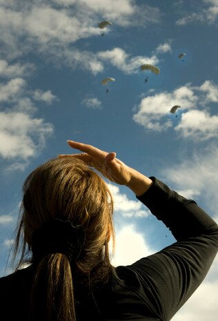 A spectator watches the sky as U.S. Air Force Airmen, 820th RED HORSE airborne flight, jump from a C-130 Hercules during the 2011 Aviation Nation Open House Nov. 12, at Nellis Air Force Base, Nev. Aviation Nation celebrates 70 years of airpower in Las Vegas and the Air Force's accomplishments in air, space and cyberspace. (U.S. Air Force photo by Staff Sgt. Christopher Hubenthal/Released)