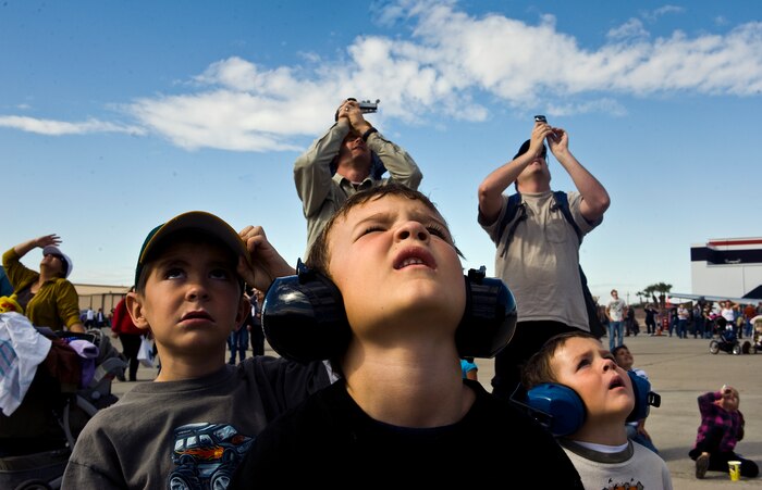 Spectators watch the sky as U.S. Air Force Airmen, 820th RED HORSE airborne flight, jump from a C-130 Hercules during the 2011 Aviation Nation Open House Nov. 12, at Nellis Air Force Base, Nev. Aviation Nation celebrates 70 years of airpower in Las Vegas and the Air Force's accomplishments in air, space and cyberspace. (U.S. Air Force photo by Staff Sgt. Christopher Hubenthal/Released)